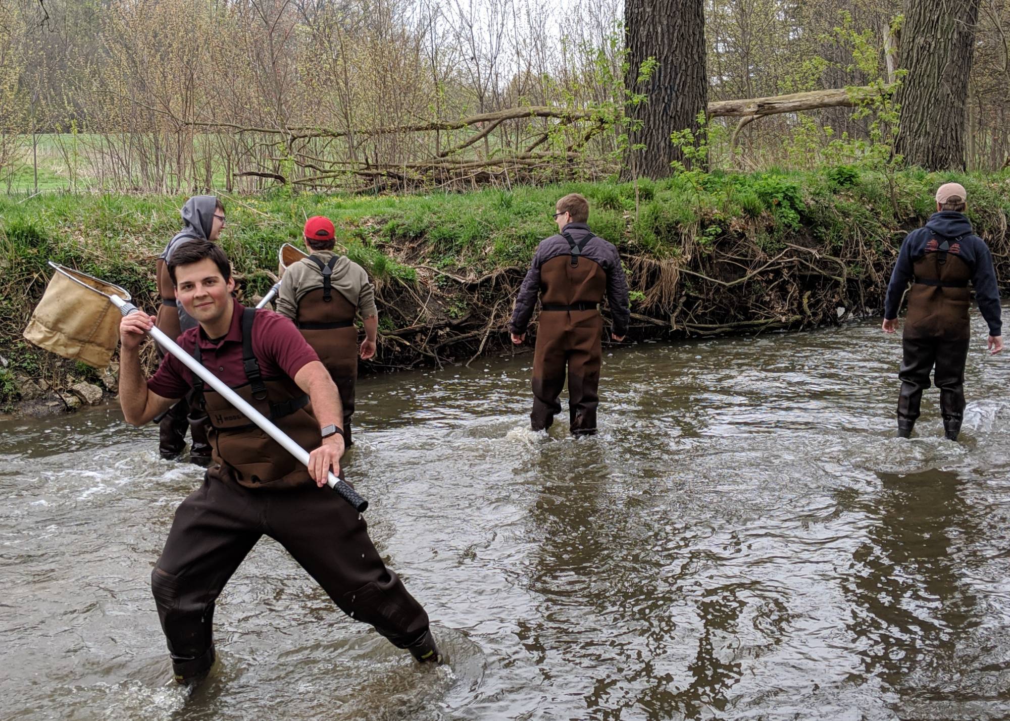 Student from Wellspring Prep stands in a stream with a net
